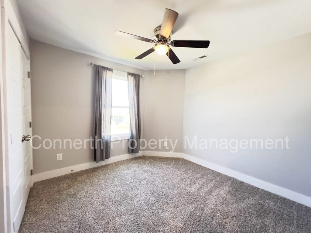 Empty room with carpet, window and fan with light