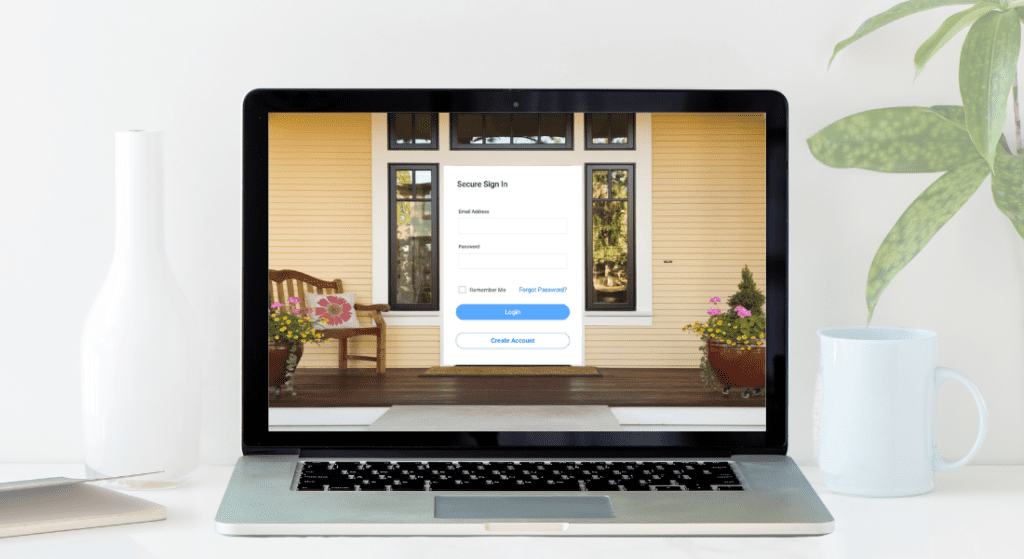 Laptop on a white desk displaying a secure sign-in page with fields for email and password. A potted plant, white vase, and mug are next to the laptop. Importance of Tenant Web Access in Property Management