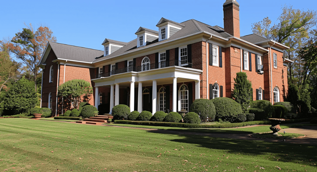 A large red brick house with white columns, multiple windows, and a well-manicured lawn on a clear day. how to attract tenant in clarksville