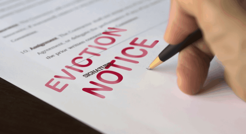 A hand signing a document labeled "EVICTION NOTICE" in large red letters.
